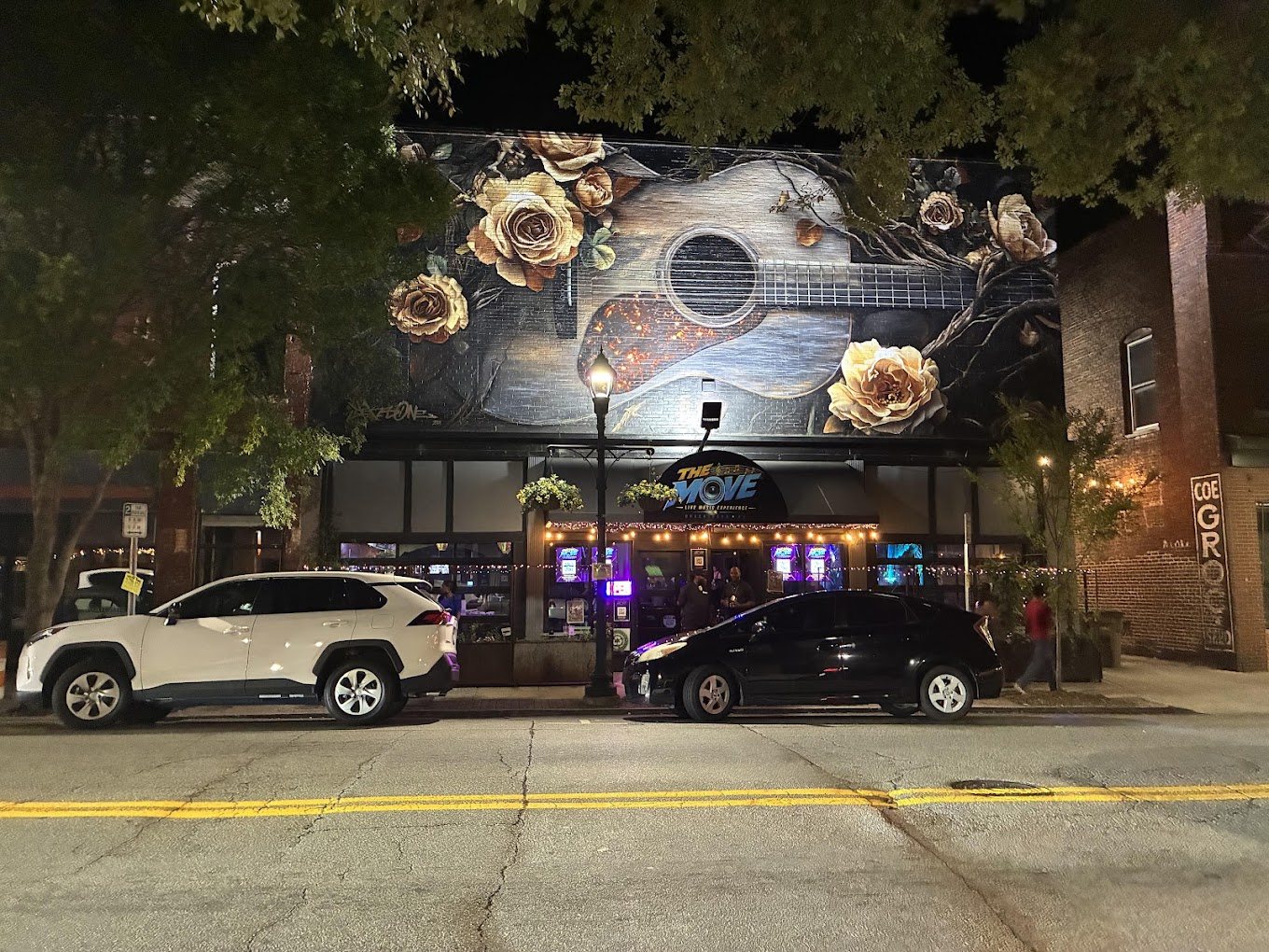 The Move at night with the guitar mural above it